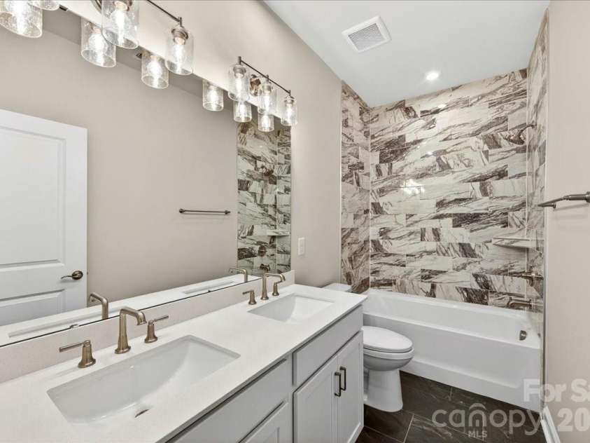 183 Landy Street, Fort Mill, SC 29715.  MLS# CAR4360547, YatesRealty ID 14679. Dual Vanity secondary bathroom with tiled walls above the tub