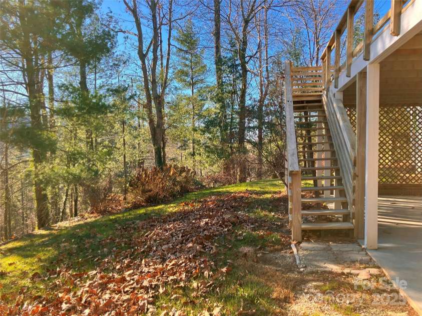 23 Moriah Lane, Asheville, NC 28803.  MLS# CAR4221443, YatesRealty ID 1468. Patio leading out to great backyard area and stairs up to the expansive main-level deck from the kitchen and living room.