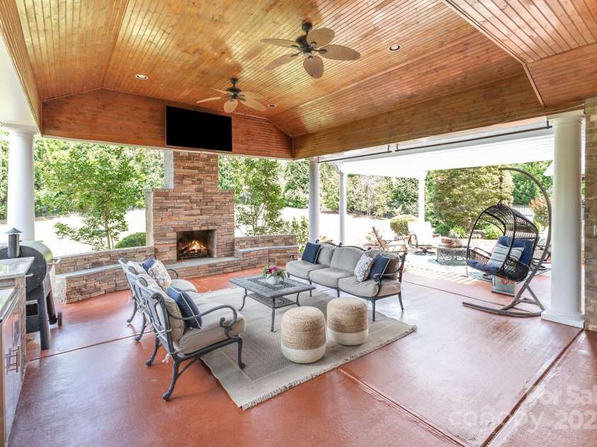 10202 Alouette Drive, Waxhaw, NC 28173.  MLS# CAR4250954, YatesRealty ID 14743. The private, gorgeous outdoor living space is enveloped by mature trees and bushes. The wood burning fireplace is the cornerstone of this seating area where warm summer evenings and crisp autumn nights will be enjoyed