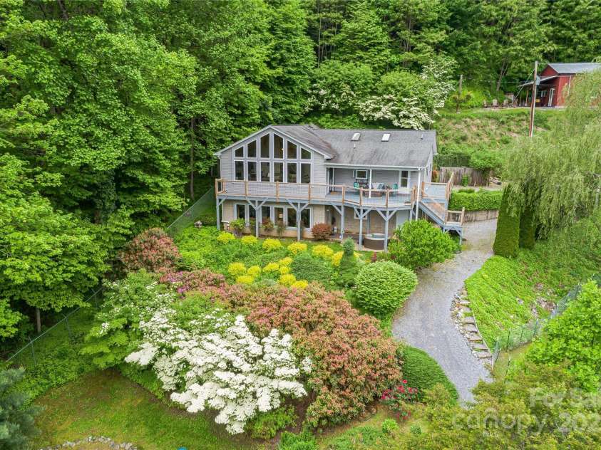 283 Grapevine Cove, Waynesville, NC 28785.  MLS# CAR4260835, YatesRealty ID 14836. A stunning setting with beautiful landscaping, raised garden beds, unique accessory buildings and the most incredible views awaits!