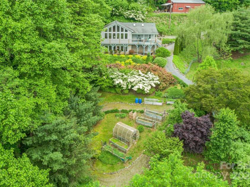 283 Grapevine Cove, Waynesville, NC 28785.  MLS# CAR4260835, YatesRealty ID 14836. Greenhouse and raised garden beds below