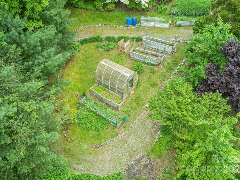 283 Grapevine Cove, Waynesville, NC 28785.  MLS# CAR4260835, YatesRealty ID 14836. Stunning landscaping and high yield raised garden beds frame the front yard. a gravel path makes for easy access by foot or small atv