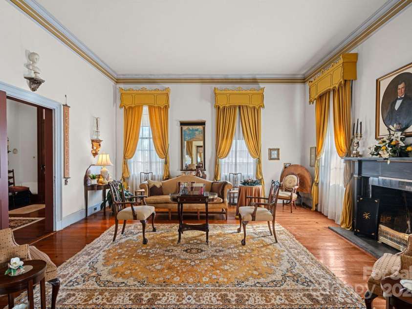 104 Leslie Loop, Mooresville, NC 28115.  MLS# CAR4195674, YatesRealty ID 149. The front Parlor has 14-ft ceilings, original heart pine floors and a black & gold Federal mantlepiece