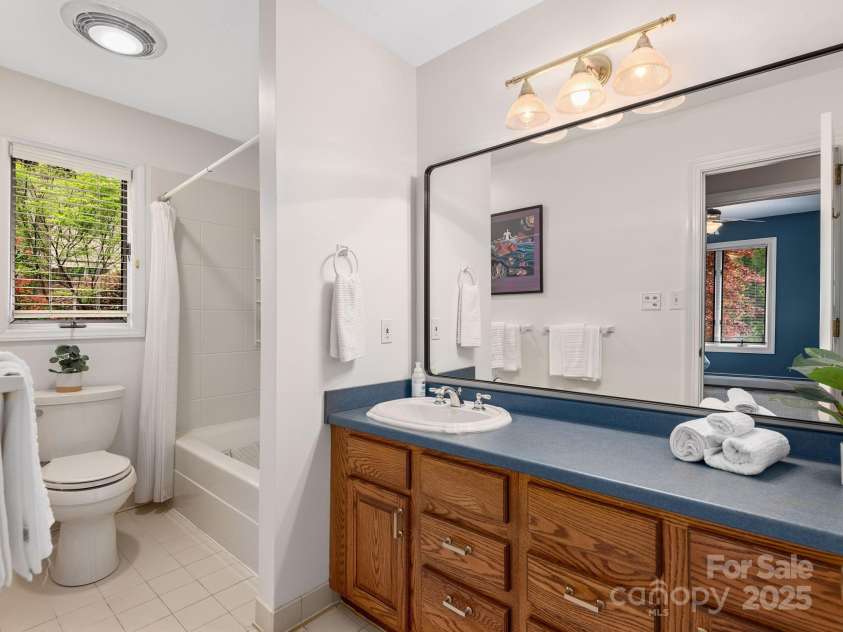 308 Sondley Drive, Asheville, NC 28805.  MLS# CAR4202100, YatesRealty ID 14904. Spacious second bathroom on main level with tile floors and wood vanity cabinets