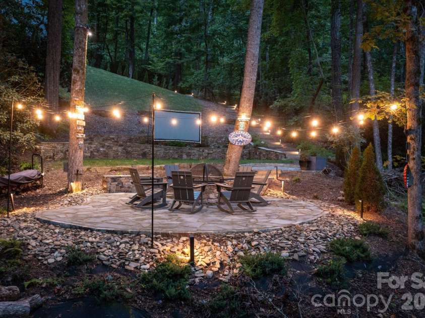 559 Shining Rock Path, Horse Shoe, NC 28742.  MLS# CAR4372540, YatesRealty ID 14910. Flagstone patio with a central fire pit, and string lights, create an inviting space for gatherings.