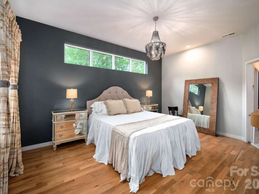 559 Shining Rock Path, Horse Shoe, NC 28742.  MLS# CAR4372540, YatesRealty ID 14910. Spacious primary suite with bold accent wall and clerestory windows with serene treetop views.