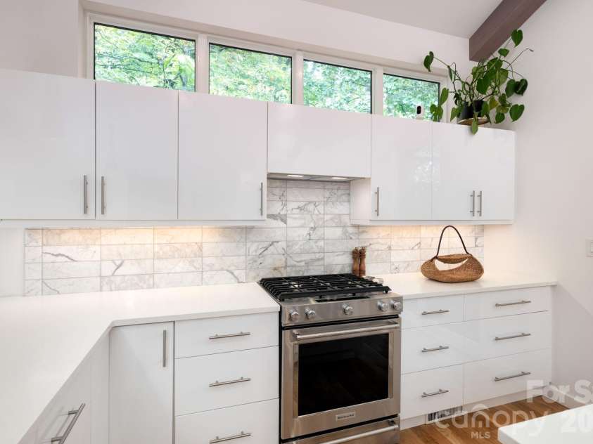 559 Shining Rock Path, Horse Shoe, NC 28742.  MLS# CAR4372540, YatesRealty ID 14910. Stainless range framed by modern cabinetry and tile backsplash.