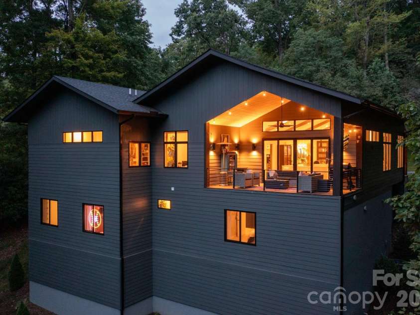 559 Shining Rock Path, Horse Shoe, NC 28742.  MLS# CAR4372540, YatesRealty ID 14910. Warm interior glow, showcasing architectural lines and covered deck.