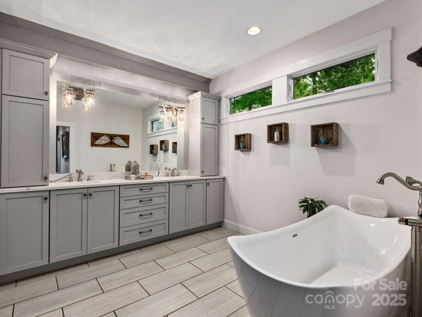 15 Bonnies Lane, Asheville, NC 28803.  MLS# CAR4252426, YatesRealty ID 14917. Free standing soaking tub in the primary bathroom with double sinks.