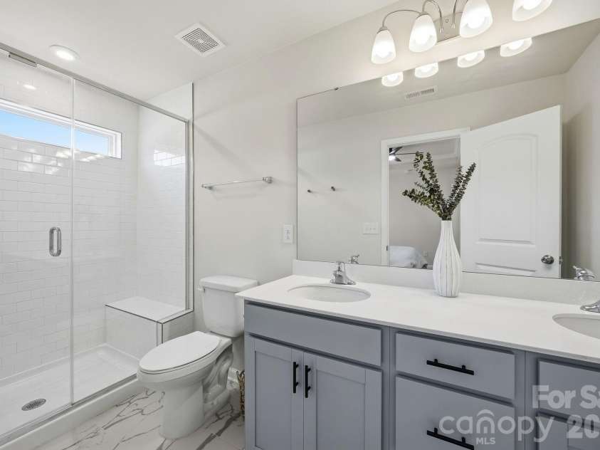 15617 Little Bluestem Street, Charlotte, NC 28278.  MLS# CAR4373465, YatesRealty ID 14925. Primary bath with dual sinks and tiled shower with bench seat