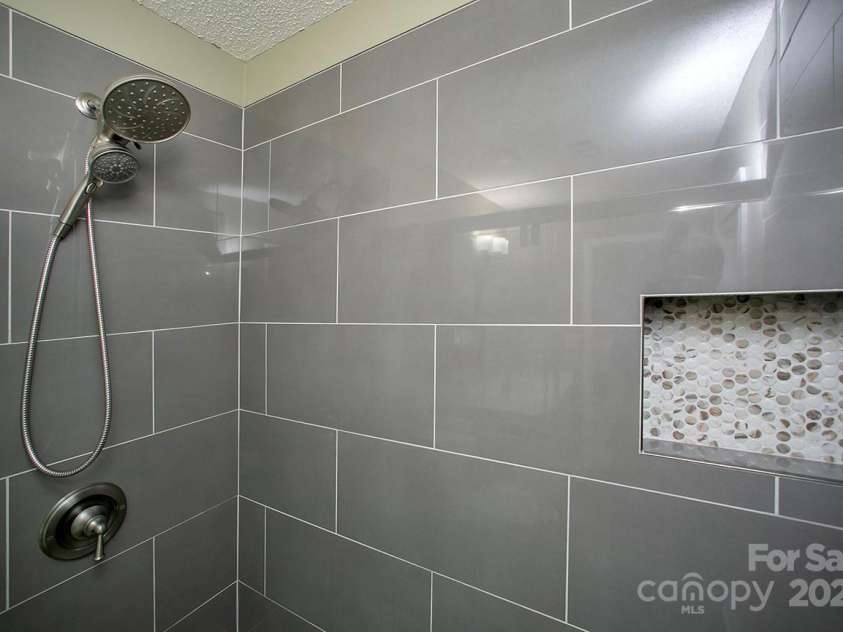 1610 Ford Street, Charlotte, NC 28216.  MLS# CAR4257993, YatesRealty ID 14930. Your walk-in shower has gorgeous tile work and a big bench seat, too.