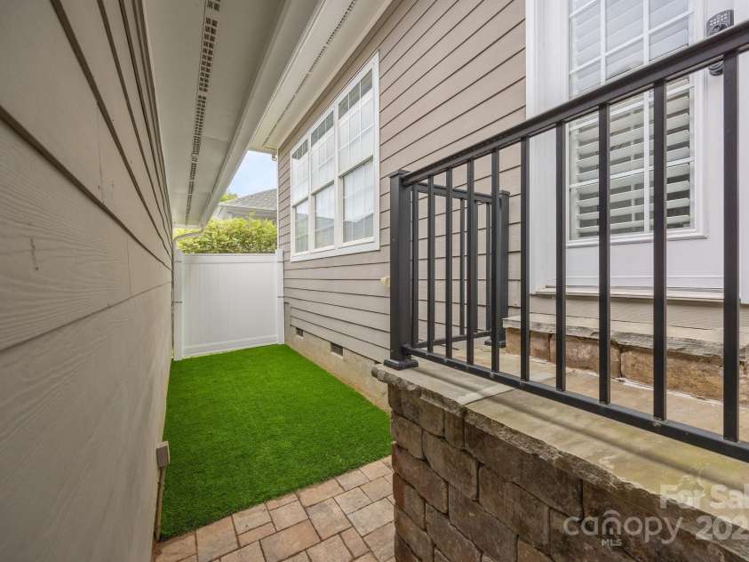 15913 Trenton Place Road, Huntersville, NC 28078.  MLS# CAR4259795, YatesRealty ID 14953. Space between the home and detached garage with artificial turf and a 6' privacy panel
