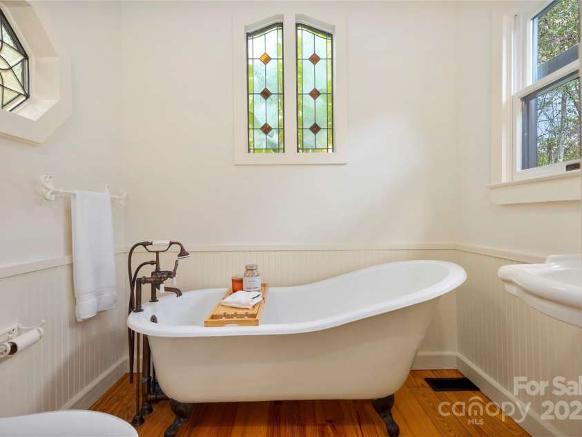 528 Padgettown Road, Black Mountain, NC 28711.  MLS# CAR4261507, YatesRealty ID 1499. Secondary Bedroom ensuite bath with claw foot tub and stained glass windows. 