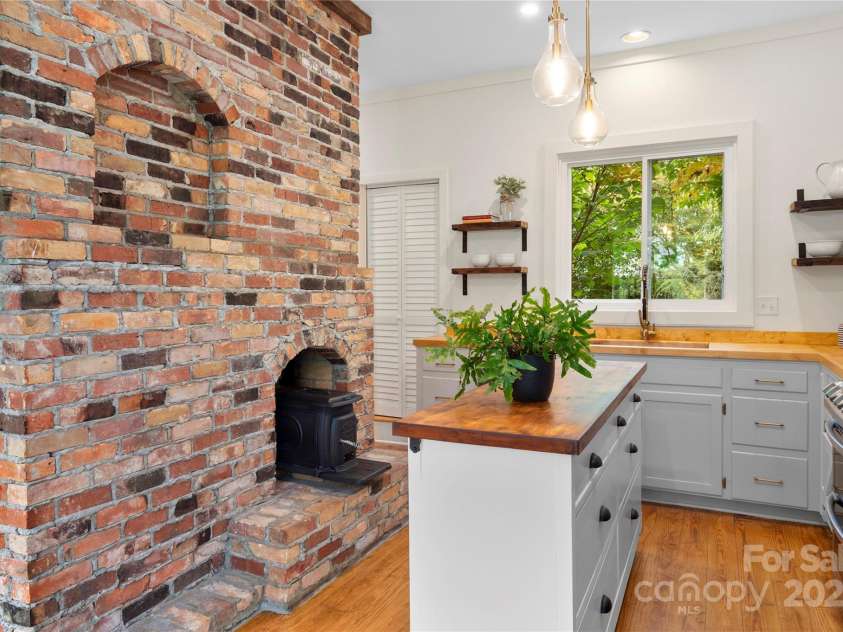 528 Padgettown Road, Black Mountain, NC 28711.  MLS# CAR4261507, YatesRealty ID 14998. Newly remodeled kitchen with wood stove insert, butcher block counters and open shelving.