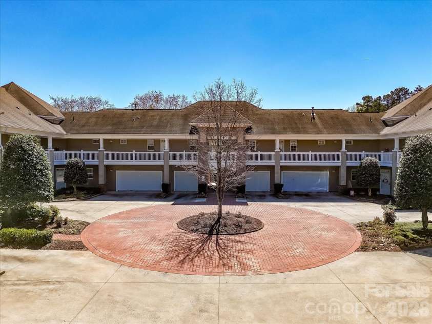 8665 Edinburgh Square Drive, Cornelius, NC 28031.  MLS# CAR4357240, YatesRealty ID 15038. Charming community exterior featuring a welcoming courtyard design with well-maintained landscaping and convenient garage access.