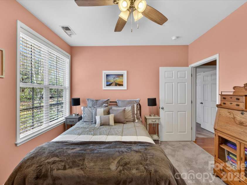 8665 Edinburgh Square Drive, Cornelius, NC 28031.  MLS# CAR4357240, YatesRealty ID 15038. Cozy third bedroom featuring soft carpeting, a ceiling fan, and abundant natural light, perfect for guests or additional living space.
