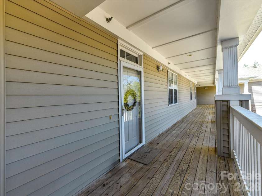 8665 Edinburgh Square Drive, Cornelius, NC 28031.  MLS# CAR4357240, YatesRealty ID 15038. Inviting covered entry with a spacious private balcony and charming front door, offering a warm welcome and added outdoor living space.