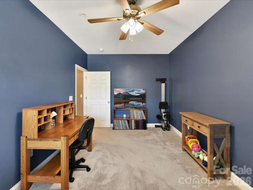 8665 Edinburgh Square Drive, Cornelius, NC 28031.  MLS# CAR4357240, YatesRealty ID 15038. Versatile second bedroom featuring plush carpeting, abundant natural light, and ample space ideal for guests, a home office, or flex use.