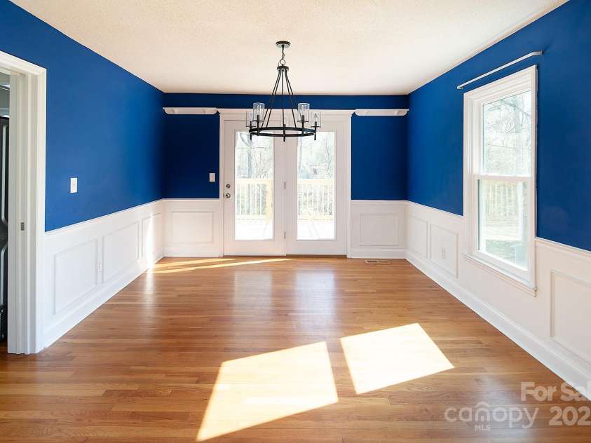 916 Rollingwood Drive, Mount Holly, NC 28120.  MLS# CAR4241352, YatesRealty ID 15080. Dining Room Hardwood Floors and French Doors to Deck Updated Lighting