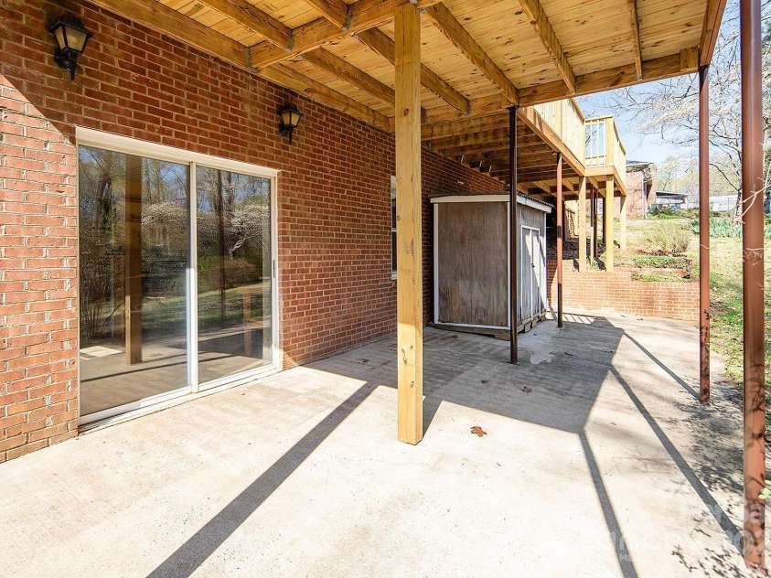 916 Rollingwood Drive, Mount Holly, NC 28120.  MLS# CAR4241352, YatesRealty ID 15080. Large patio space under deck just off Basement shop