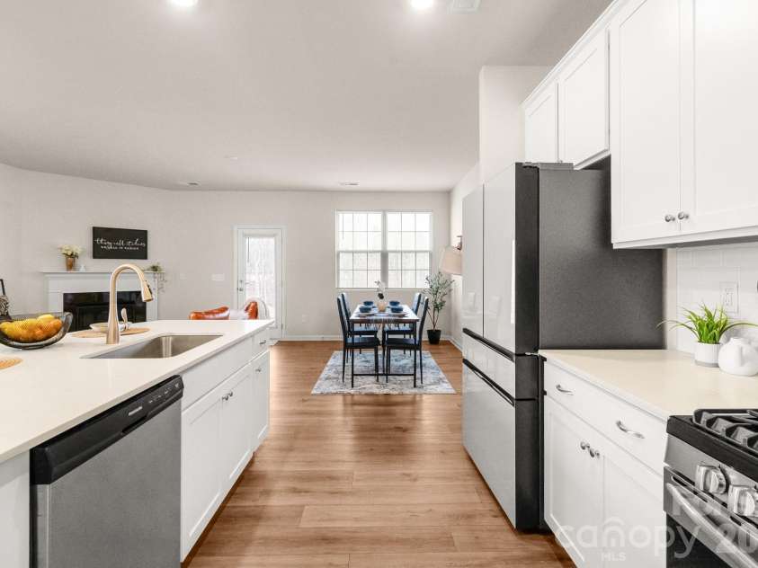 5044 Moss Pine Way, Tega Cay, SC 29708.  MLS# CAR4371971, YatesRealty ID 15096. From the island, the view stretches all the way to the dining area and patio door beyond — a layout that makes everyday living feel effortless and spacious.