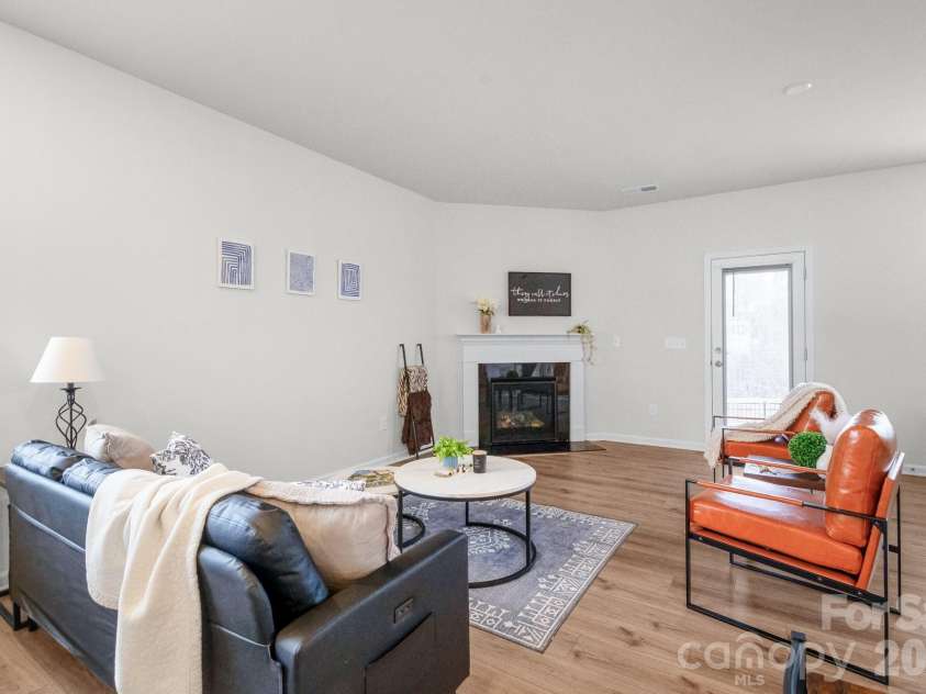 5044 Moss Pine Way, Tega Cay, SC 29708.  MLS# CAR4371971, YatesRealty ID 15096. Gather around the gas fireplace in this bright, generously sized living room with luxury vinyl plank floors and windows on two sides. Warm, welcoming, and move-in ready.