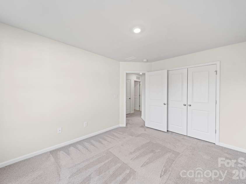 5044 Moss Pine Way, Tega Cay, SC 29708.  MLS# CAR4371971, YatesRealty ID 15096. Third bedroom with double closet doors and neutral finishes — a comfortable, flexible space ready for whatever you need it to be.
