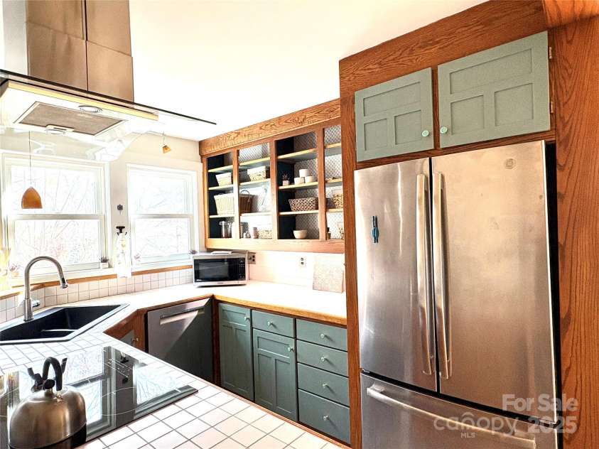 114 Broadway Avenue, Tryon, NC 28782.  MLS# CAR4322856, YatesRealty ID 15101. Well designed compact kitchen for ease of use. There is also a separate walk in pantry in this area and a second room behind the kitchen wall with the shelves.