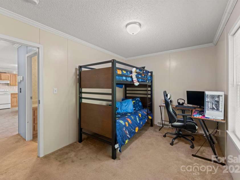 5039 Pine Springs Drive, Bessemer City, NC 28016.  MLS# CAR4249727, YatesRealty ID 15175. Bedroom 3 located at the end of the house towards the back.  This room also has a large walk in closet with plenty of storage. To the left you can see the secondary bathroom and a glimpse of the kitchen