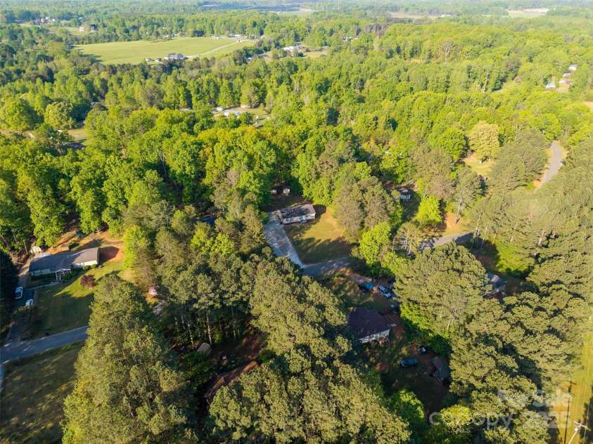 5039 Pine Springs Drive, Bessemer City, NC 28016.  MLS# CAR4249727, YatesRealty ID 15175. Drone shot of the property in the center of the pic showcasing the privacy of the lot