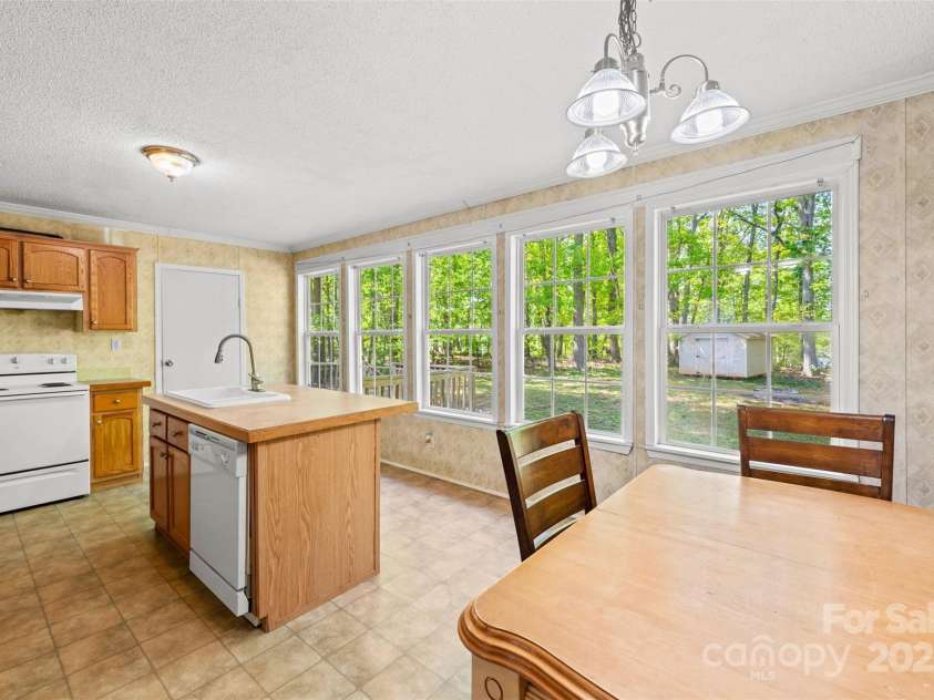 5039 Pine Springs Drive, Bessemer City, NC 28016.  MLS# CAR4249727, YatesRealty ID 15175. Kitchen and breakfast area featuring this large kitchen great for entertaining.  The door to the left is the laundry room.