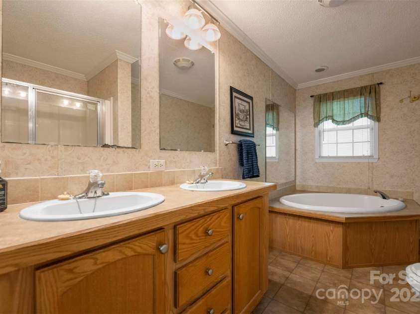 5039 Pine Springs Drive, Bessemer City, NC 28016.  MLS# CAR4249727, YatesRealty ID 15175. Large primary bathroom with double vanity and spa like garden tub