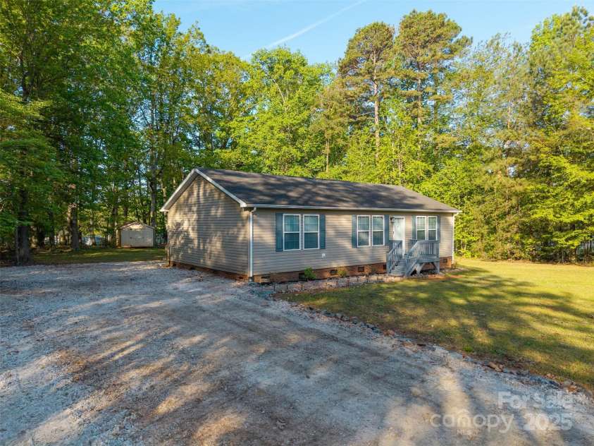 5039 Pine Springs Drive, Bessemer City, NC 28016.  MLS# CAR4249727, YatesRealty ID 15175. Side view of the property showing off all of the parking near the house and one of the sheds in the back yard