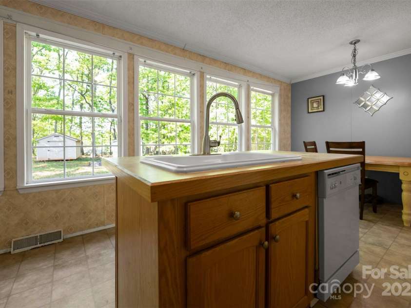 5039 Pine Springs Drive, Bessemer City, NC 28016.  MLS# CAR4249727, YatesRealty ID 15175. View of the large, private back yard from the kitchen sink/island.  Featuring large windows letting in lots of natural light