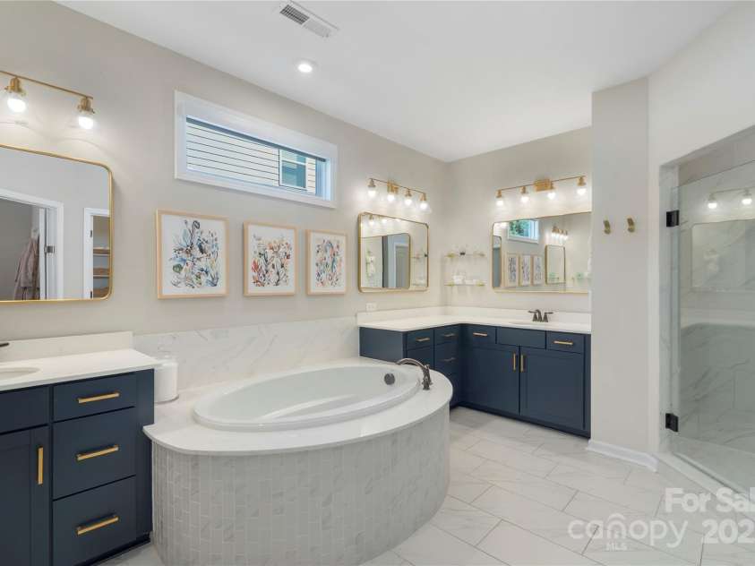 5050 Havencrest Drive, Fort Mill, SC 29715.  MLS# CAR4261068, YatesRealty ID 15224. Spa-like primary suite with separate vanities and garden tub with tile surround.