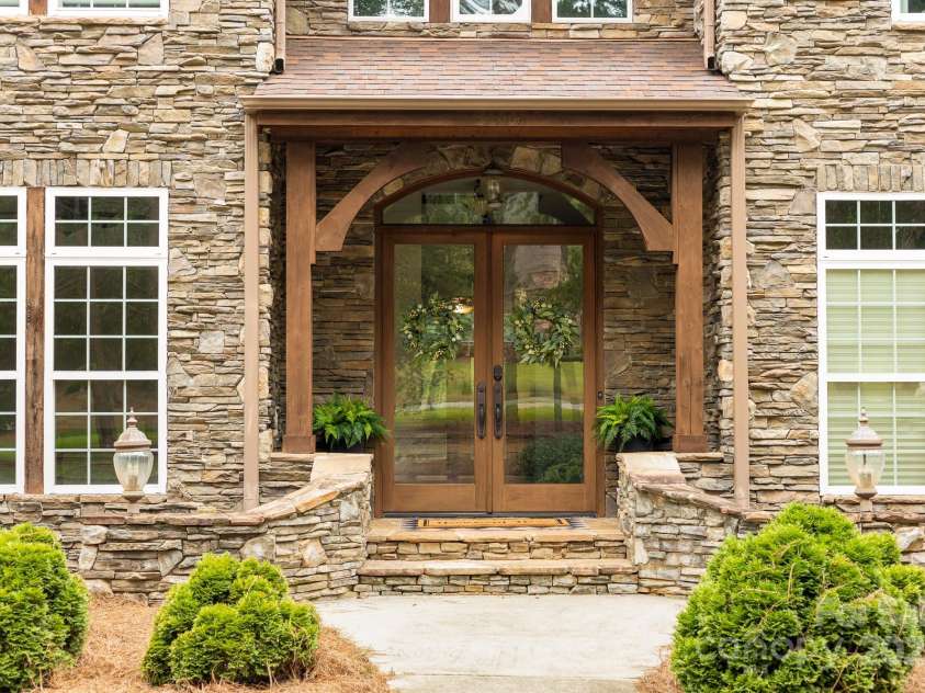 14504 Henry Harrison Stillwell Drive, Huntersville, NC 28078.  MLS# CAR4288907, YatesRealty ID 1530. Double glass door entryway with stone and wood accents
