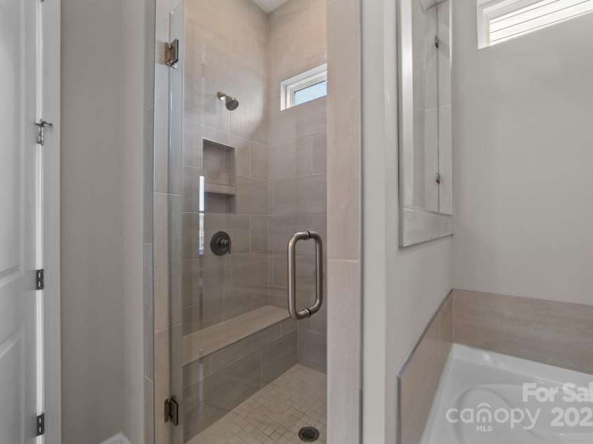 197 Tetcott Street, Mooresville, NC 28115.  MLS# CAR4238933, YatesRealty ID 15313. Stand-up shower w/ bench in primary owner's suite.