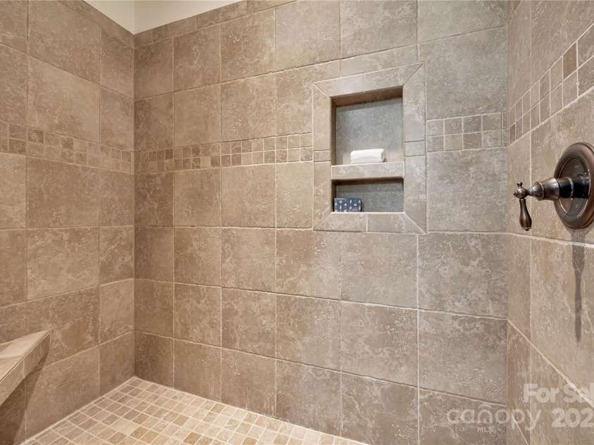 224 Corsica Lane, Saluda, NC 28773.  MLS# CAR4294125, YatesRealty ID 15383. Walk-in tile shower in primary bathroom