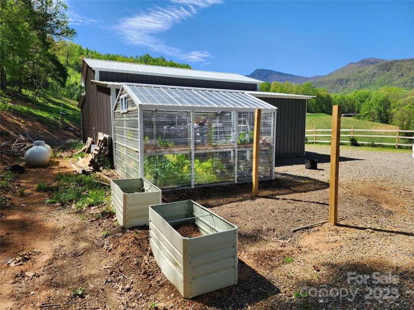583 Cane Branch Road, Burnsville, NC 28714.  MLS# CAR4251066, YatesRealty ID 15423. Greenhouse near garage