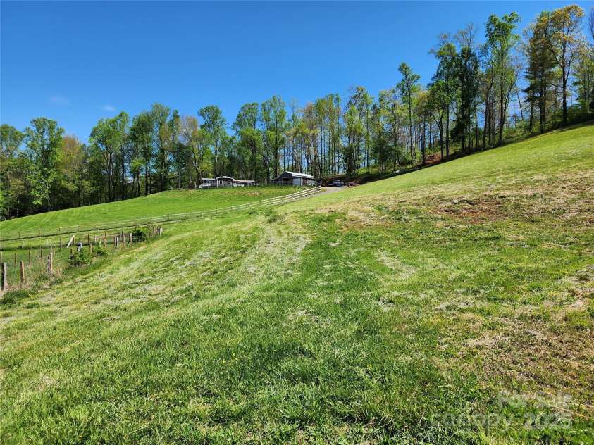 583 Cane Branch Road, Burnsville, NC 28714.  MLS# CAR4251066, YatesRealty ID 15423. Looking up to the house from near the barn