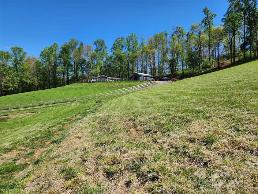 583 Cane Branch Road, Burnsville, NC 28714.  MLS# CAR4251066, YatesRealty ID 15423. Looking up to the house from the pasture/hayfield