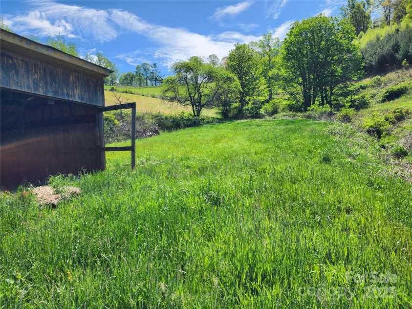 583 Cane Branch Road, Burnsville, NC 28714.  MLS# CAR4251066, YatesRealty ID 15423. Lush grass surrounding barn on the south side of the property