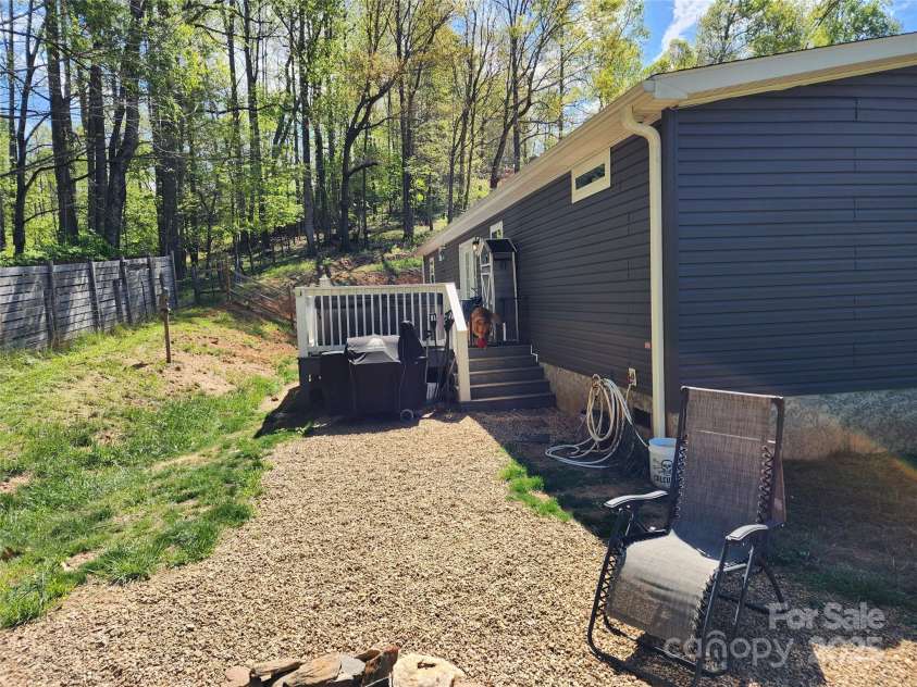 583 Cane Branch Road, Burnsville, NC 28714.  MLS# CAR4251066, YatesRealty ID 15423. Side yard and deck accessed from the dining area