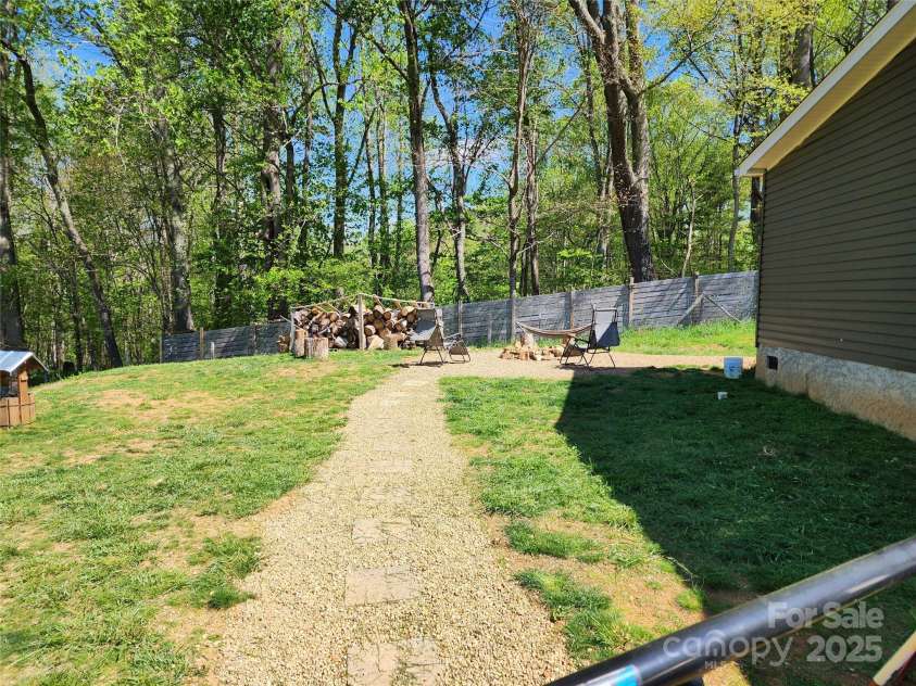 583 Cane Branch Road, Burnsville, NC 28714.  MLS# CAR4251066, YatesRealty ID 15423. Side yard with walkway - fully fenced in.