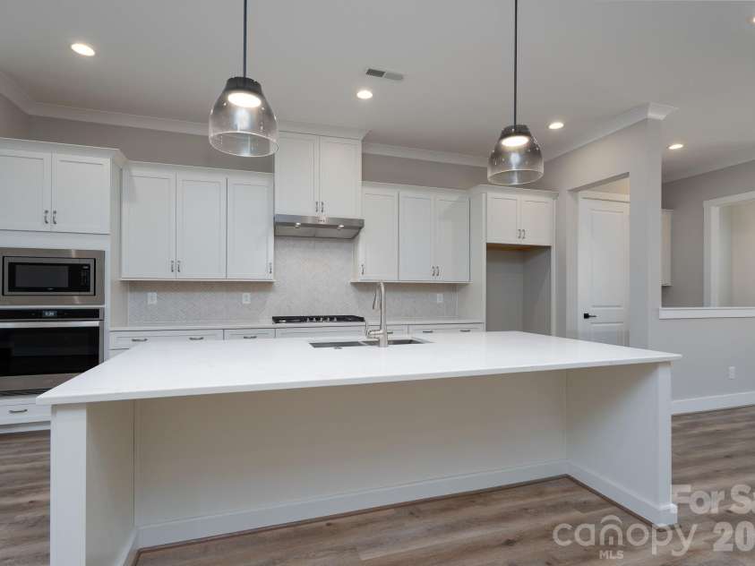 15132 Rocky Bluff Loop, Davidson, NC 28036.  MLS# CAR4351498, YatesRealty ID 15525. Kitchen island with herring bone backsplash
