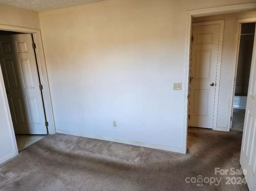 20 Coventry Lane, Burnsville, NC 28714.  MLS# CAR4199768, YatesRealty ID 1557. Primary Bedroom showing entrance and ensuite bathroom doors