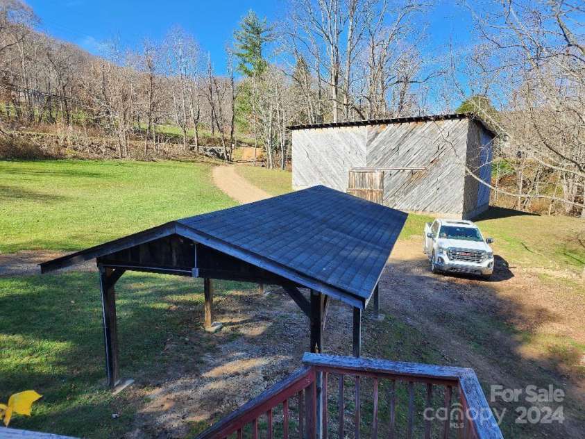 20 Coventry Lane, Burnsville, NC 28714.  MLS# CAR4199768, YatesRealty ID 1557. View of carport and barn beyond