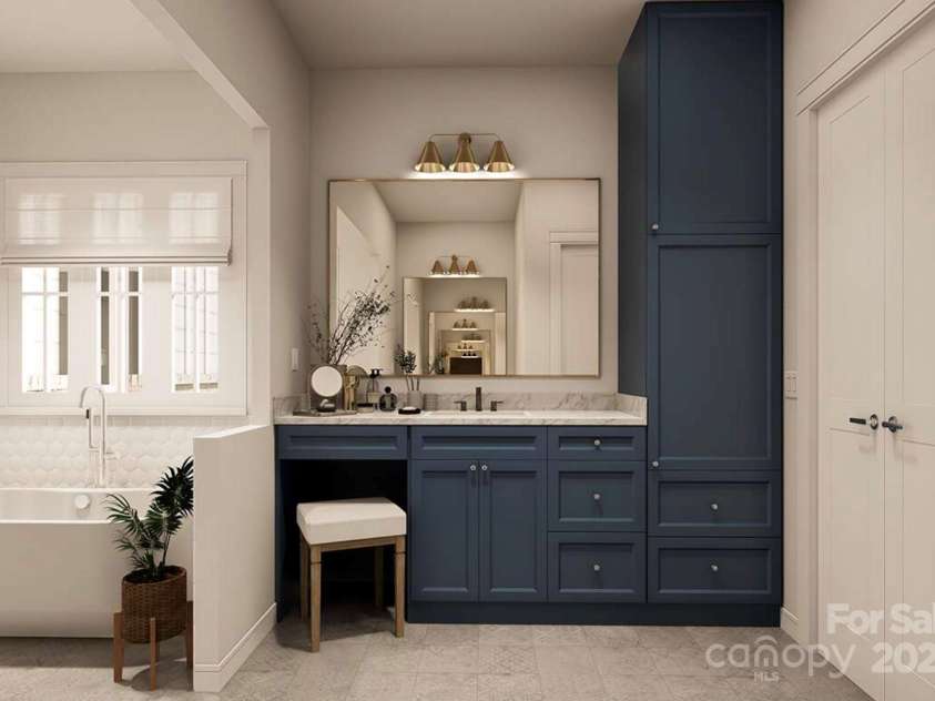 Lot 4 Country Estates Drive, Waxhaw, NC 28173.  MLS# CAR4278303, YatesRealty ID 1561. Navy blue cabinetry with marble countertops and brass fixtures adds a bold yet elegant touch, complemented by a dedicated vanity area and built-in storage tower for optimal functionality.
