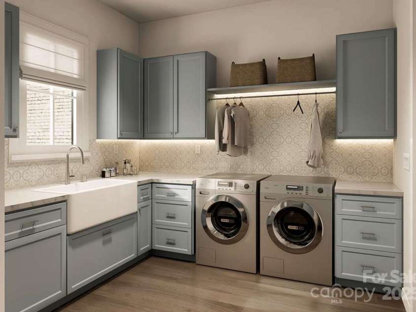 Lot 4 Country Estates Drive, Waxhaw, NC 28173.  MLS# CAR4278303, YatesRealty ID 1561. This beautifully appointed laundry room combines charm and utility with soft blue cabinetry, patterned backsplash tile, and warm wood flooring.