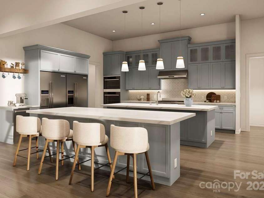 Lot 4 Country Estates Drive, Waxhaw, NC 28173.  MLS# CAR4278303, YatesRealty ID 1561. This gourmet kitchen is a perfect blend of style and functionality. It features soft blue-gray custom cabinetry, sleek quartz countertops, and a double island layout that offers ample space for meal prep and casual